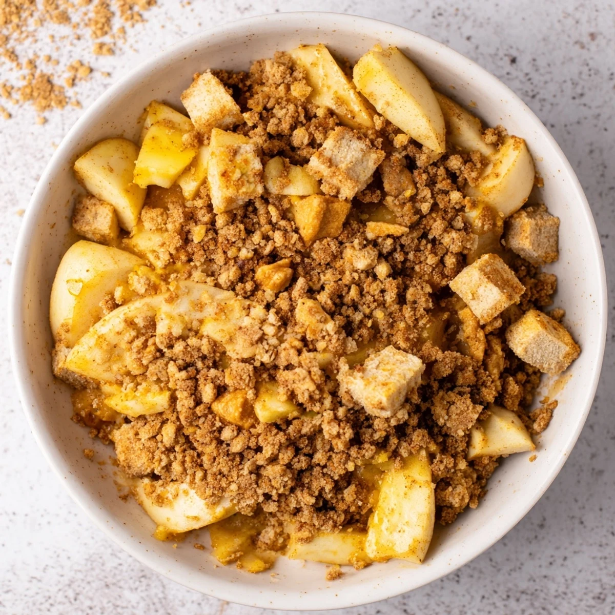 Enjoy a warm spoonful of homemade Warm Rustic Apple and Cinnamon Crumble, smelling of cinnamon and baked apples.