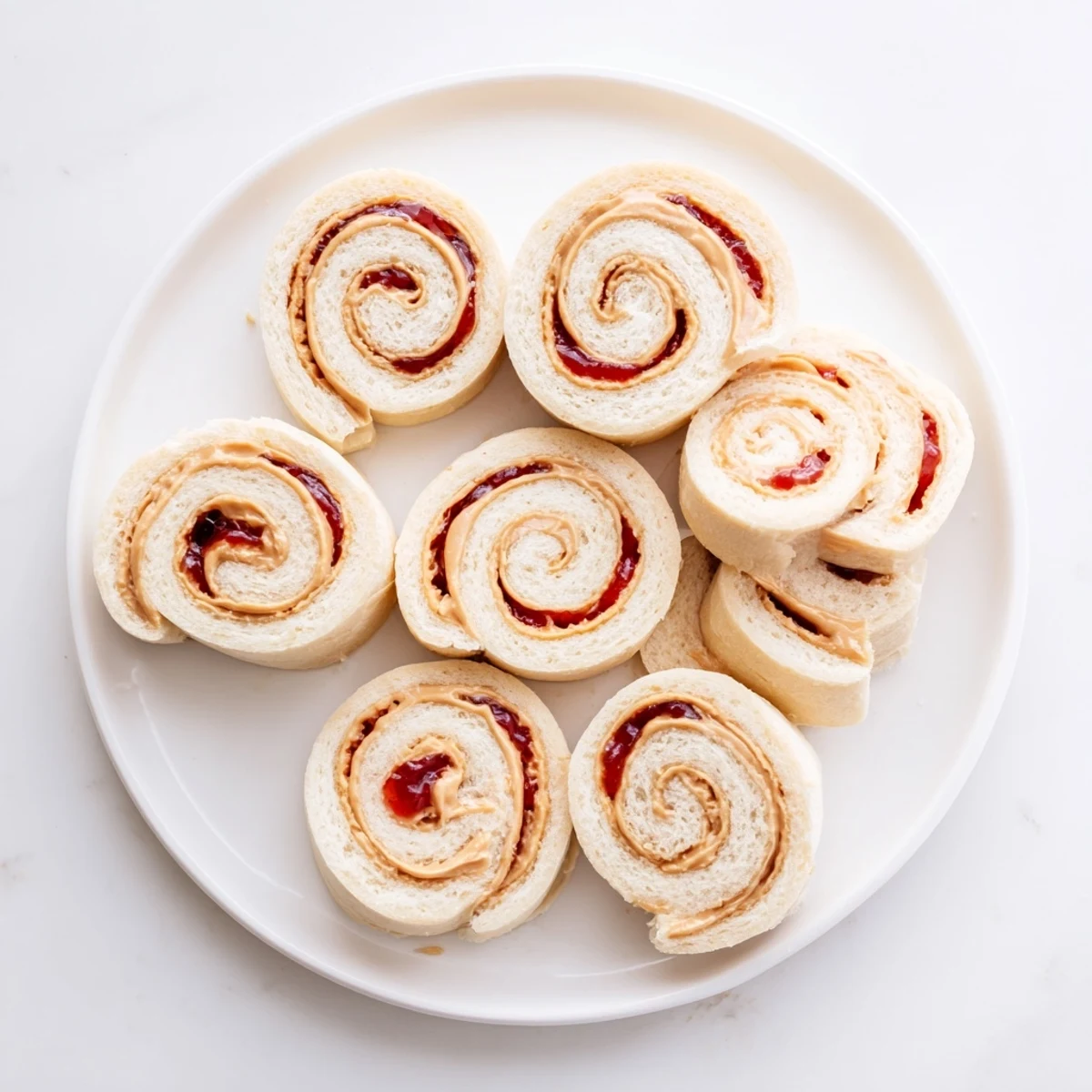 Freshly made Simple Sandwich PB&J pinwheel rolls, sliced and ready to eat, a fun and easy kid's lunch.