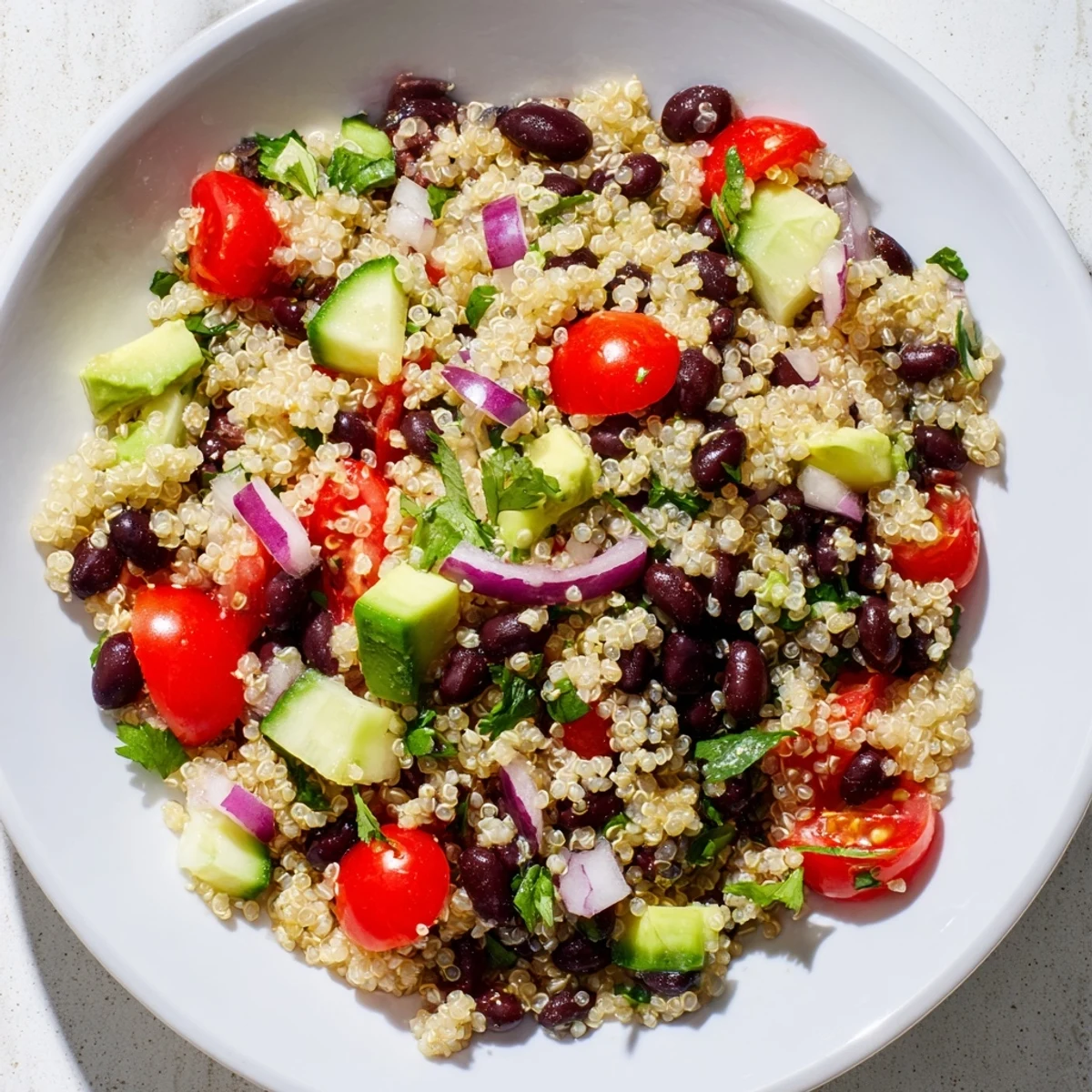 Hearty Quinoa Black Bean Salad with creamy avocado, tossed in a zesty lime dressing.