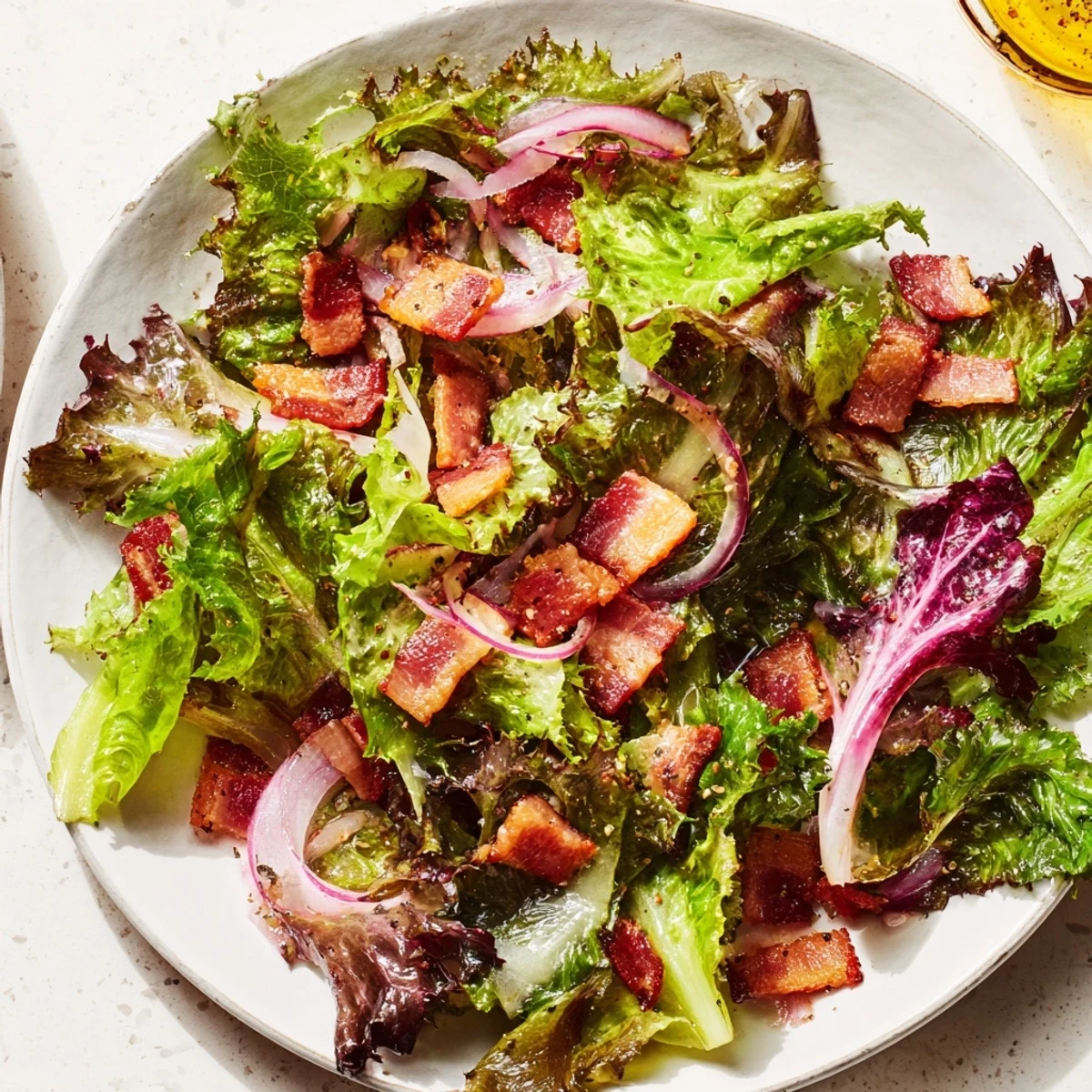 Close-up shot shows a delicious Bitter Greens Salad with crispy bacon pieces and nuts.
