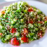 A close-up of colorful Lebanese Tabbouleh Salad, tossed with fresh parsley and a tangy oil dressing.