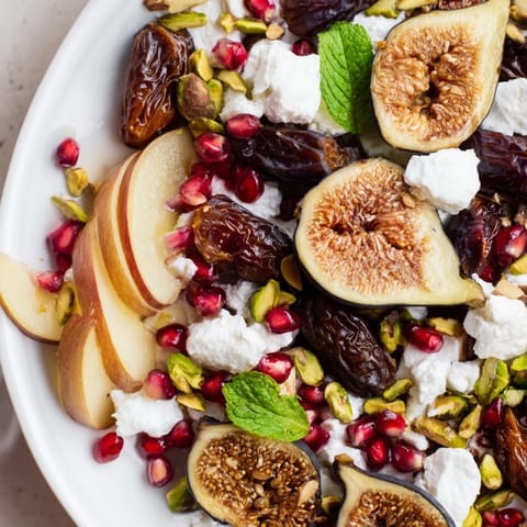 Festive winter fruit: a fig and date snowdrift platter, garnished with pomegranate seeds and pistachios.