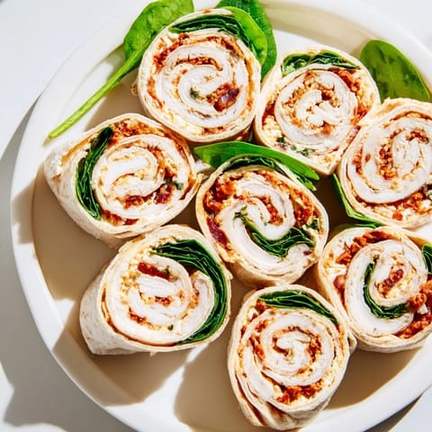 Beautifully presented Sun-Dried Tomato Turkey Roll-Ups, ready to eat; a vibrant lunch or snack.