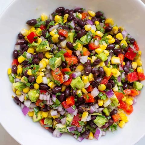 A refreshing bowl of Southwest Black Bean Salad, full of crunchy vegetables and creamy avocado.
