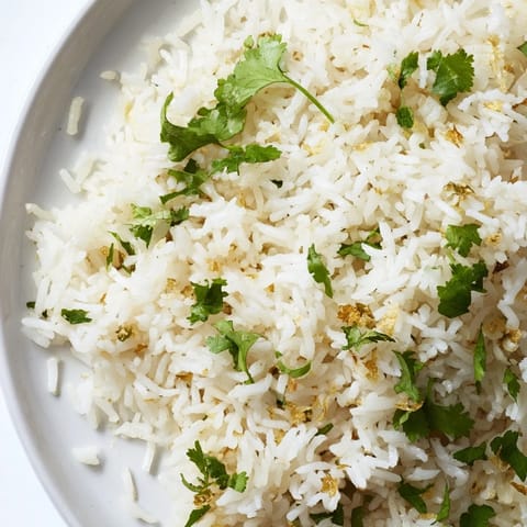 A bowl of aromatic Jasmine Rice Garlic served beside vibrant stir-fried vegetables for a complete meal.