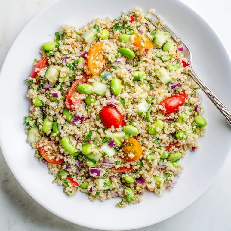 Edamame and Quinoa Salad served in a rustic ceramic bowl, topped with fresh parsley and mint, perfect for a healthy gluten-free lunch.