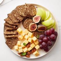 The Harvest Scythe bread and fruit platter, showcasing sliced breads and vibrant, juicy fruits, looks delicious.