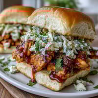 Mouthwatering BBQ chicken sliders topped with creamy coleslaw, served on soft toasted buns for a perfect 4th of July BBQ.  