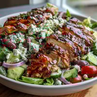 Vibrant Greek salad bowl with juicy grilled chicken, fresh vegetables, and tangy feta for a healthy, satisfying meal.  